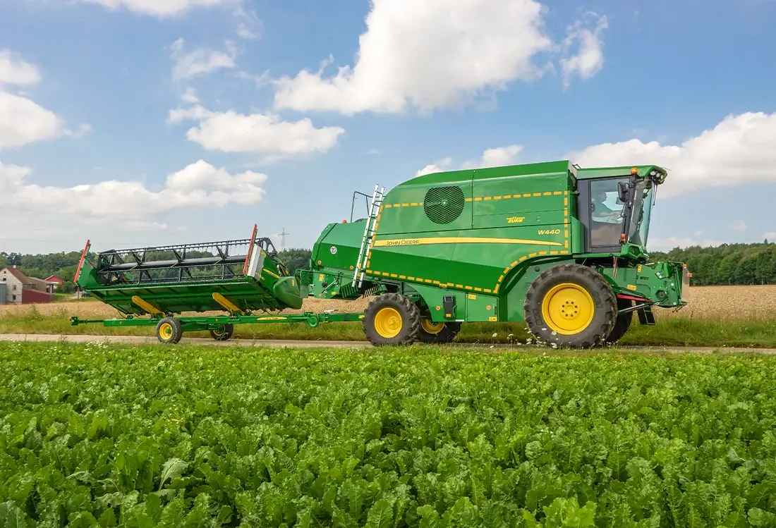 Transporter von Deere fährt auf Feldweg, Seitenansicht